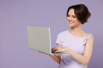 Poster - Young smiling freelancer copywriter happy brunette woman 20s with bob haircut wearing white t-shirt hold use work on laptop pc computer texting isolated on pastel purple background studio portrait