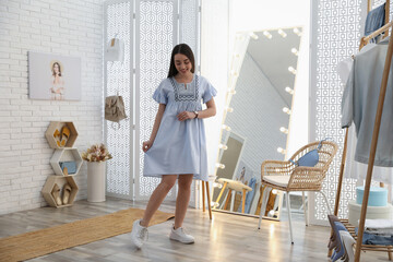 Poster - Woman trying on stylish dress in showroom