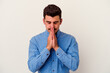 © Asier - Young caucasian man isolated on white background praying, showing devotion, religious person looking for divine inspiration.