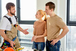 © Roman - Professional confident handyman explain how will be better to do during home renovation to young married couple, use bluprint for explanation, indoors at home