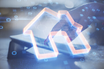 Poster - Close up of hand using tablet with creative glowing house icon on blurry background with circles. Smart home and remote control concept. Double exposure.