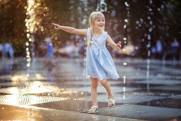 Wall Mural - happy little girl running under splashing water