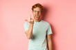 Arrogant and rude redhead man in glasses dont give a fuck, showing middle fingers at camera and frowning, standing over pink background