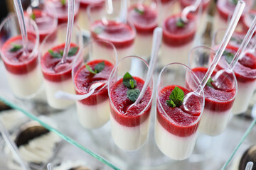 Sweet buffet table. Dish of colored cakes.