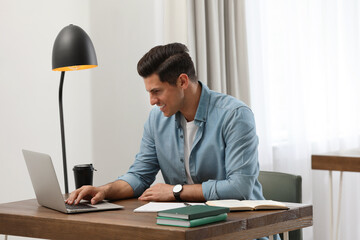 Poster - Man with laptop studying at table in library