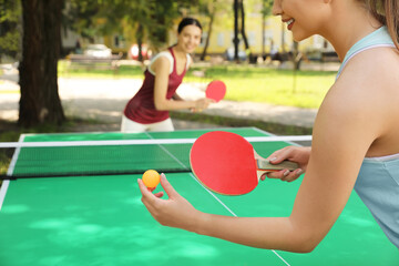 Sticker - Young women playing ping pong in park, closeup