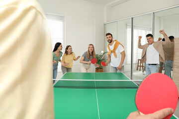 Poster - Happy friends playing ping pong together indoors