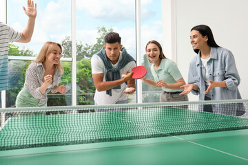 Wall Mural - Happy friends playing ping pong together indoors