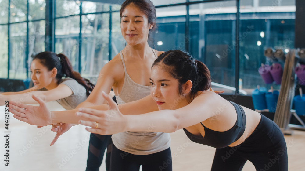 Young Asian sporty attractive people practicing yoga lesson with instructor. Asia group of women exercising healthy lifestyle in fitness studio. Sport activity, gymnastics or ballet dancing class. - obrazy, fototapety, plakaty 
