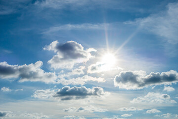 Wall Mural - the light of the sun shining through the clouds in the sky