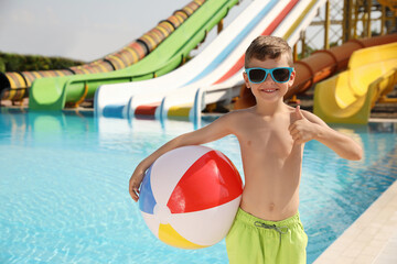 Poster - Cute little boy with inflatable ball near pool in water park, space for text