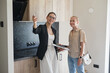 © Seventyfour - Waist up portrait of female real estate agent giving apartment tour to young woman buying new house