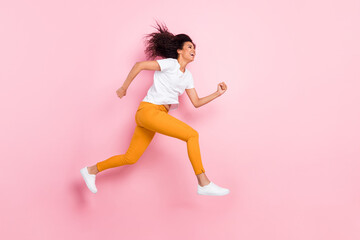 Wall Mural - Photo of pretty charming dark skin woman dressed white outfit jumping high running fast empty space isolated pink color background