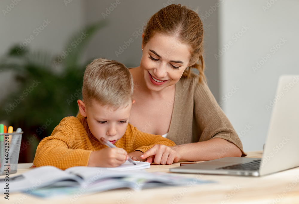 Happy mother supporting son during online studies - obrazy, fototapety, plakaty 