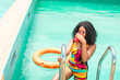 beautiful african girl sipping drink from a cup in a pool