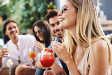 Group Of Young People Drinking Cocktails At A Summer Bar During The Day