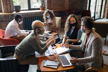 Aufkleber - Group of young managers in protective masks working over new business project