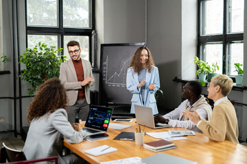 Poster - Happy young businesspeople congratulating their colleagues on successful presentation
