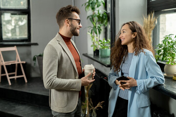 Aufkleber - Two young smiling colleagues having discussion at break in office