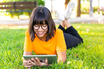 Wall Mural - Young brunette woman at outdoors holding a tablet