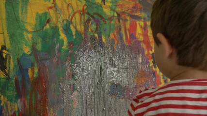 Little boy draw and art with brush and paints at home