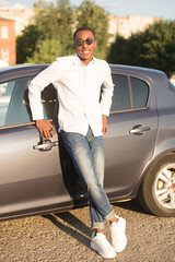 Wall Mural - happy african american next to a car in the summer