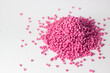 Pink granules of polypropylene or polyamide on a white background. Plastics and polymers industry. Copy space.