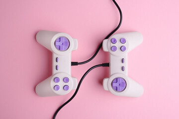 Poster - Two video game joysticks on pink background, closeup. Game addicted concept.