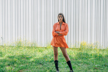 young woman in fashionable dress and boots outdoors