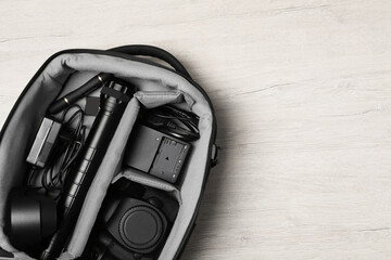 Wall Mural - professional photography equipment in backpack on wooden table, top view. space for text