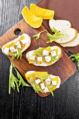 Poster - Bruschetta with pumpkin and arugula on black board top