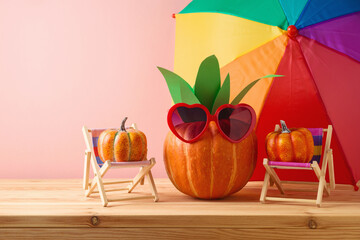 Wall Mural - Halloween pumpkin creative decor as pineapple with sunglasses on wooden table