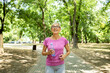 © littlewolf1989 - Smiling senior caucasian woman jogging in the park.
