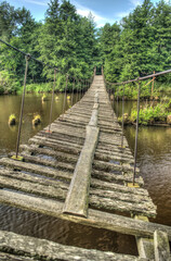 Wall Mural - Old and damaged rope and wooden boards bridge over the river Irbe, Latvia.