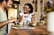 © Drobot Dean - Middle eastern man and woman smiling while having breakfast at home