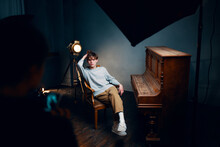 Guy Sitting On A Chair Next To The Piano Posing Photo