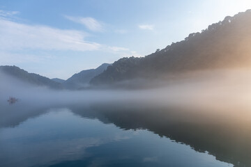 Wall Mural - river covered with white fog in sunrise