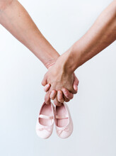 Couple Hands Holding Baby Girl Shoes