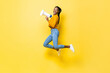 © Atstock Productions - Joyful young African American woman holding megaphone jumping and making announcement in isolated studio yellow background