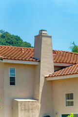 Canvas Print - Exterior of a house building with tiled roof under a clear blue sky