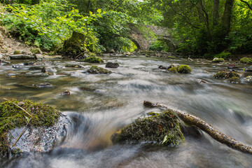 Canvas Print - Rushing water under a bridge.