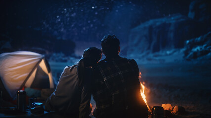 Wall Mural - Happy Couple Camping in the Canyon, Sitting Watching Campfire and Starry sky Together, She Rests Her Head on His Shoulder. Two Traveling people On Inspirational Vacation Trip Marvel at Milky Way Stars