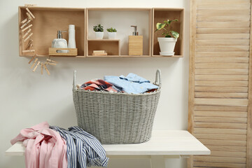 Poster - Wicker basket with dirty laundry on white table in bathroom