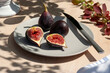 Ripe figs on grey plate in natural light