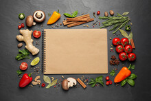 Open Recipe Book And Different Ingredients On Black Table, Flat Lay. Space For Text