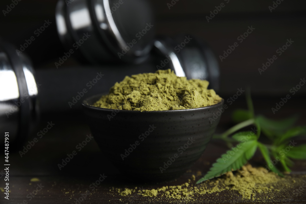 Hemp protein powder and fresh leaves on wooden table, closeup - obrazy, fototapety, plakaty 