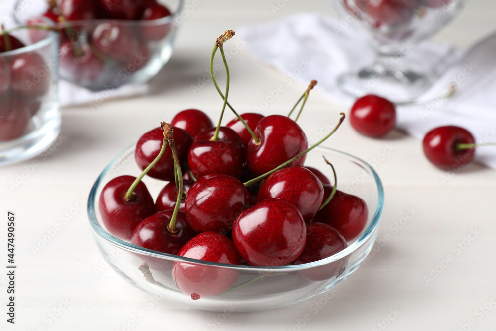 Sweet red cherries in bowl on white wooden table, closeup - obrazy, fototapety, plakaty 