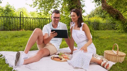 Poster - leisure and people concept - happy couple with tablet pc computer having picnic at summer park