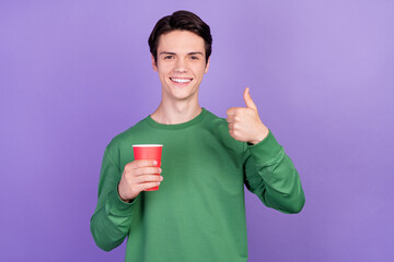 Sticker - Photo of young handsome guy happy positive smile show thumb-up drink paper cup isolated over violet color background