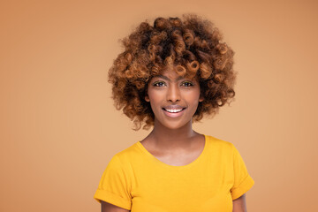 Wall Mural - Beauty portrait of young attractive afro woman with perfect smile and delicate glamour makeup with yellow eyeliner.